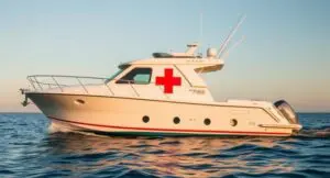 Medical boat with red cross on ocean.