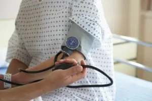Blood pressure being measured in hospital setting.